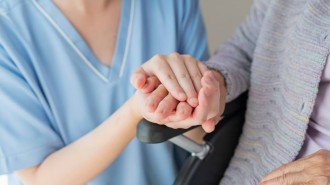 Care worker holding elderly hand