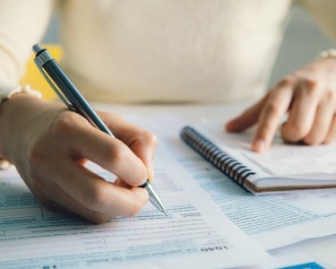 Closeup woman filling form of Individual Income Tax Return