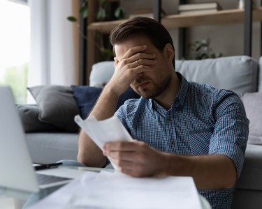Stressed Man with checking bills 