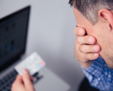 Upset man looking at his credit card