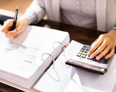 Women filling out forms and using a calculator 